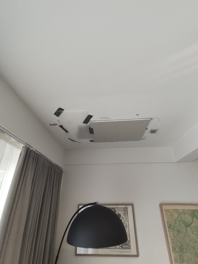 Plaque de plafond endommagée dans une pièce blanche.