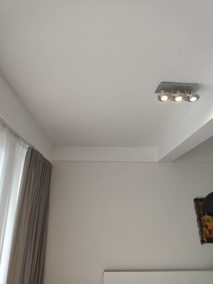 La photo montre un plafond avec une lumière et une fenêtre.