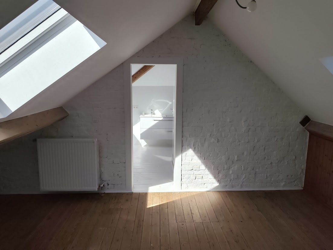 Un espace de vie intime dans une maison avec une grande fenêtre et un radiateur.