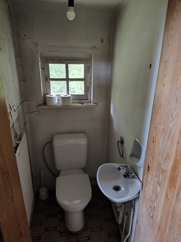 Une petite salle de bain ancienne avec un lavabo et une toilette.